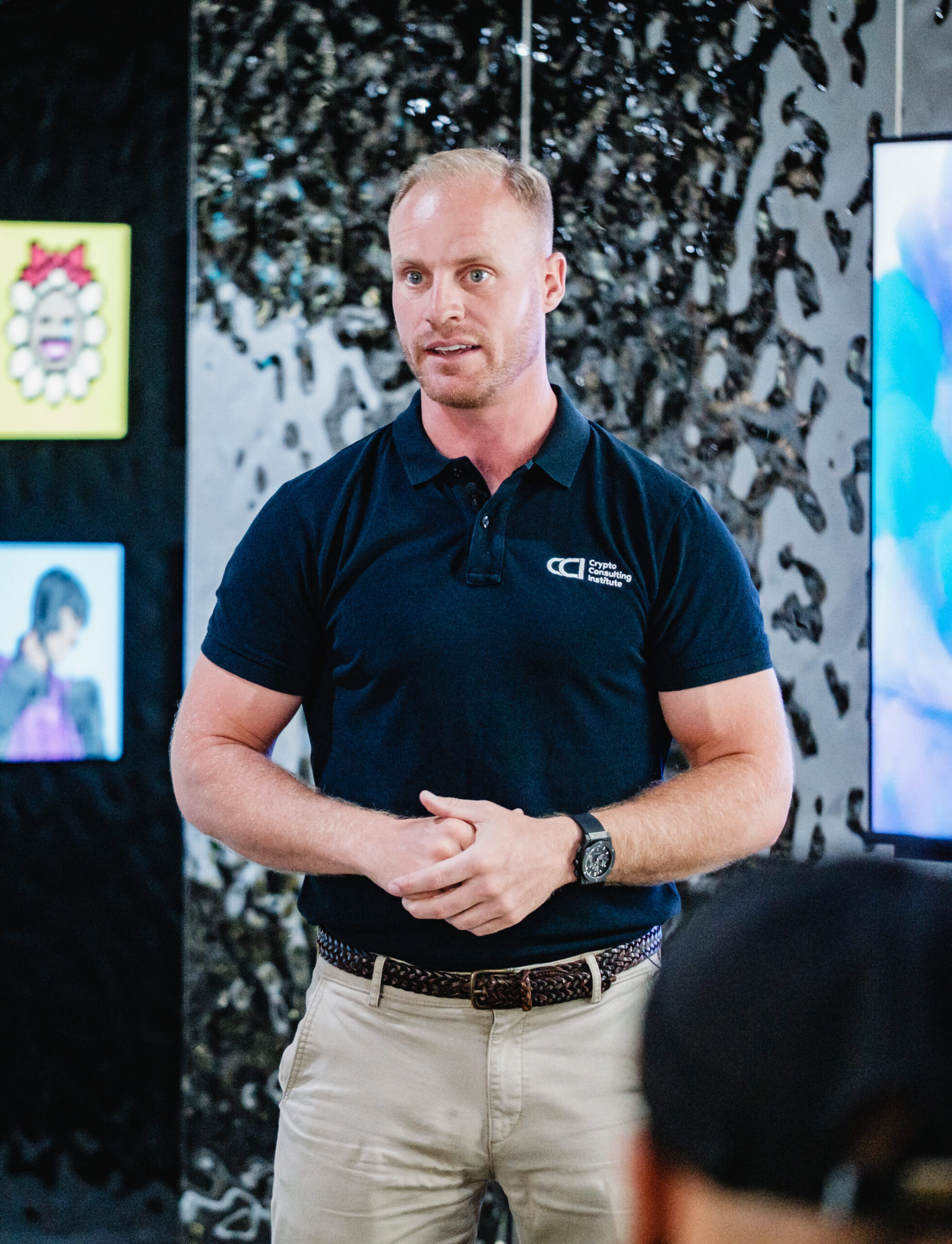 Joe Shew speaking to an audience in front of a mirrored wall
