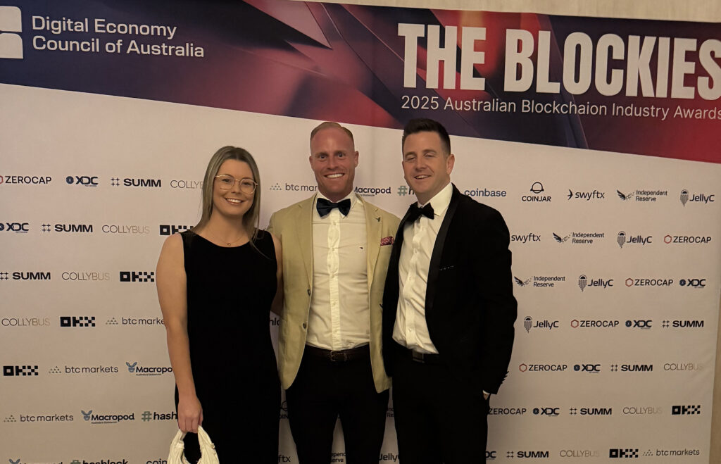 Three people in formal dress at The Blockies awards backdrop